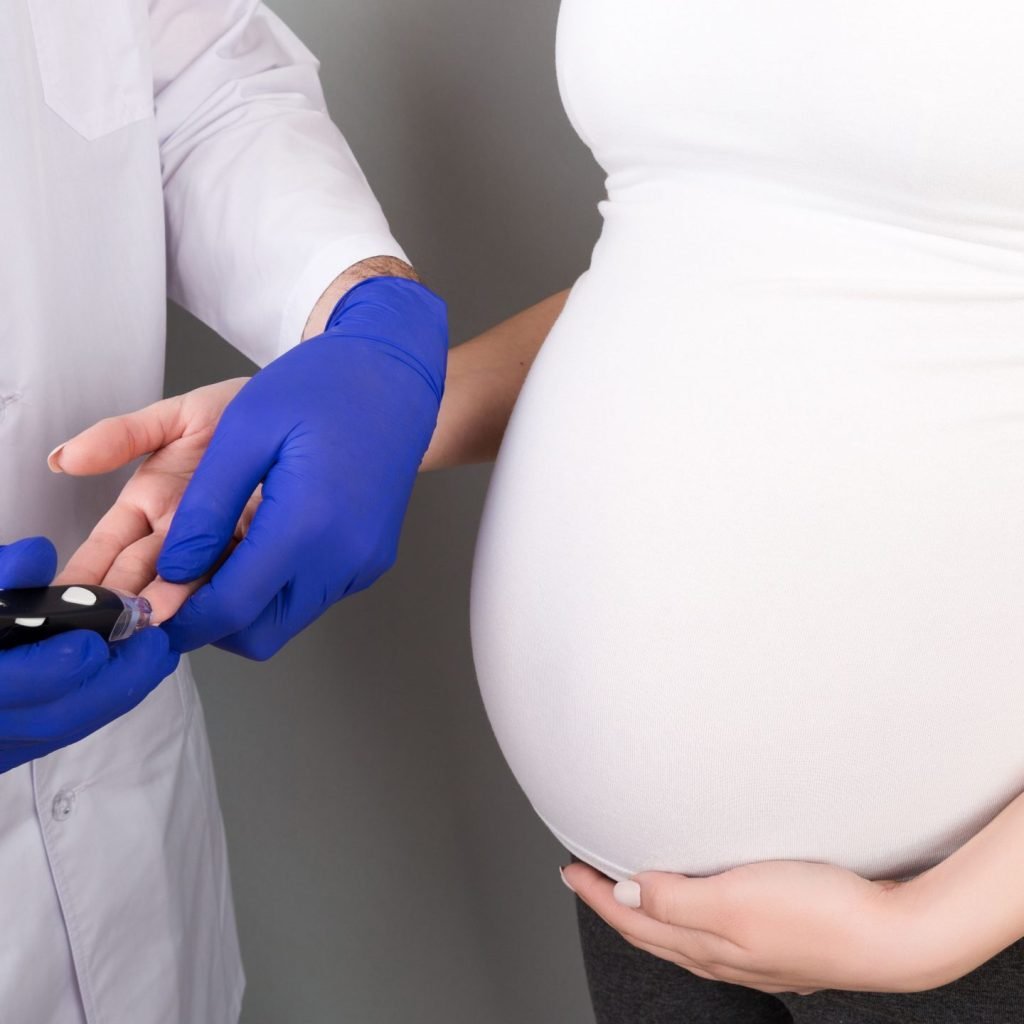 An Obstetrician measuring blood sugar of a pregnant woman for gestational diabetes.