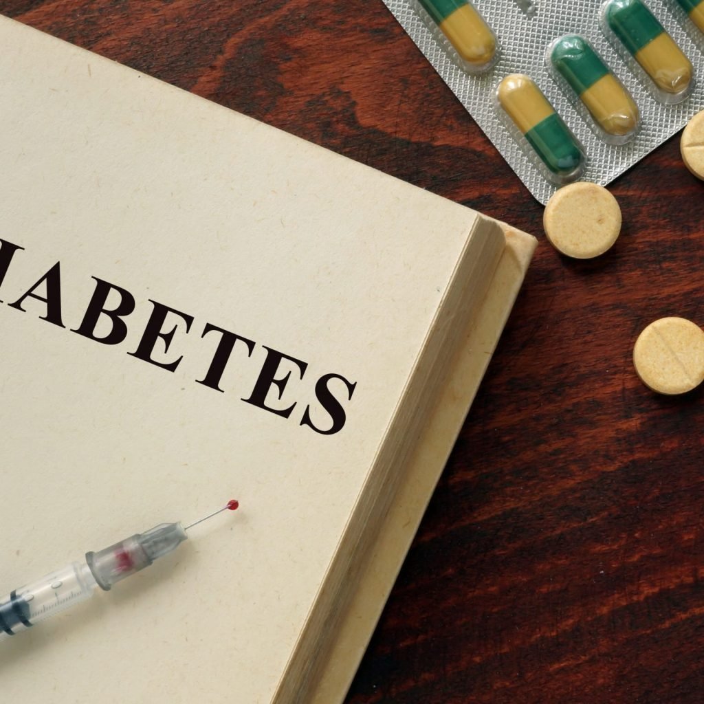 The first page of a book on prediabetes along with a syringe and medication for the condition.