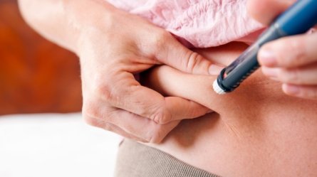 An image of a woman with type 1 diabetes injecting insulin into her body.