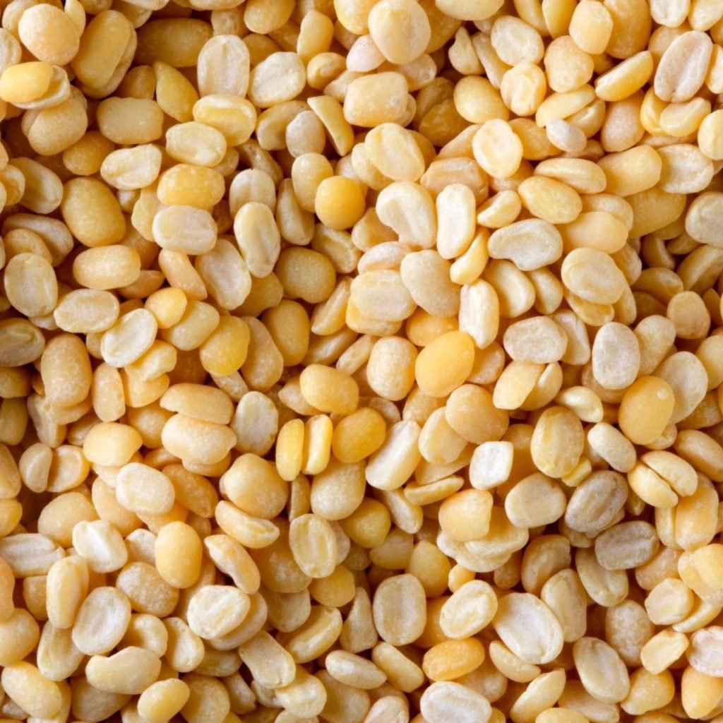 An image of Moong dal, also known as mung beans, scattered around, and it is considered one of the top Indian pulses.
