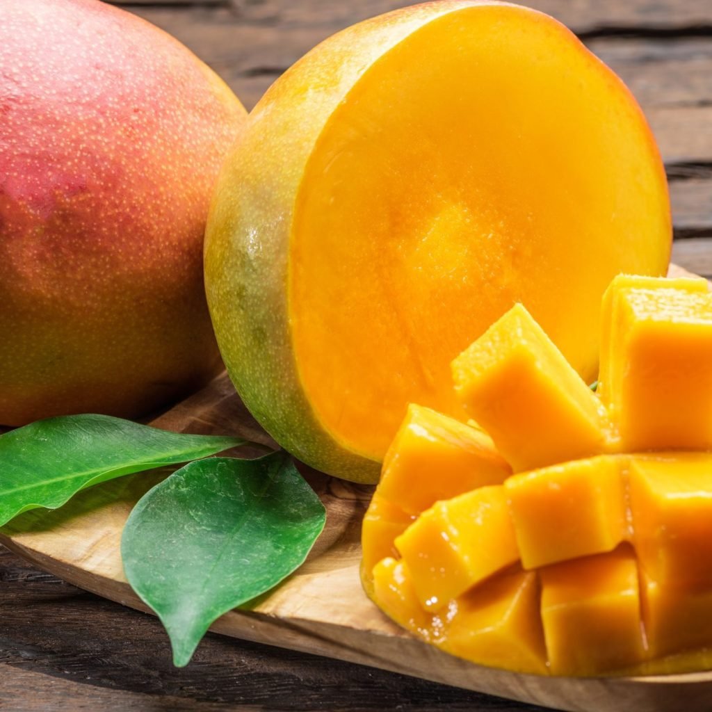 Ripe mangoes artistically sliced on a small plate.