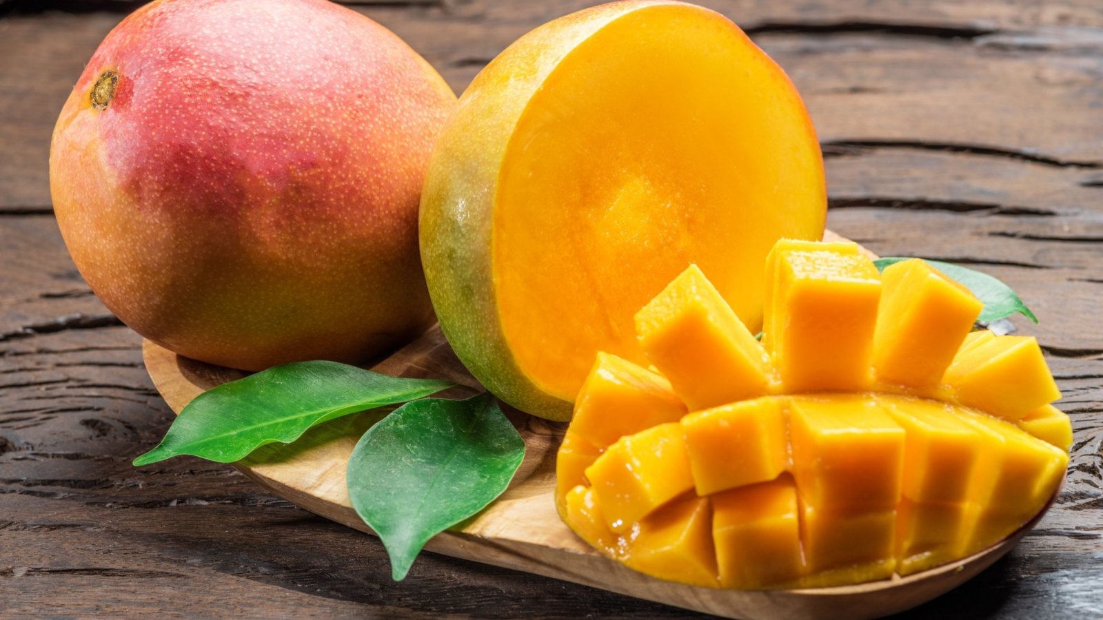 Ripe mangoes artistically sliced on a small plate.