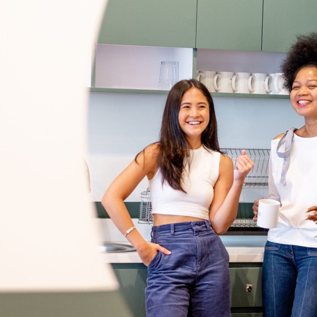 Two women enjoying some Stress Relieving Foods at their office pantry.